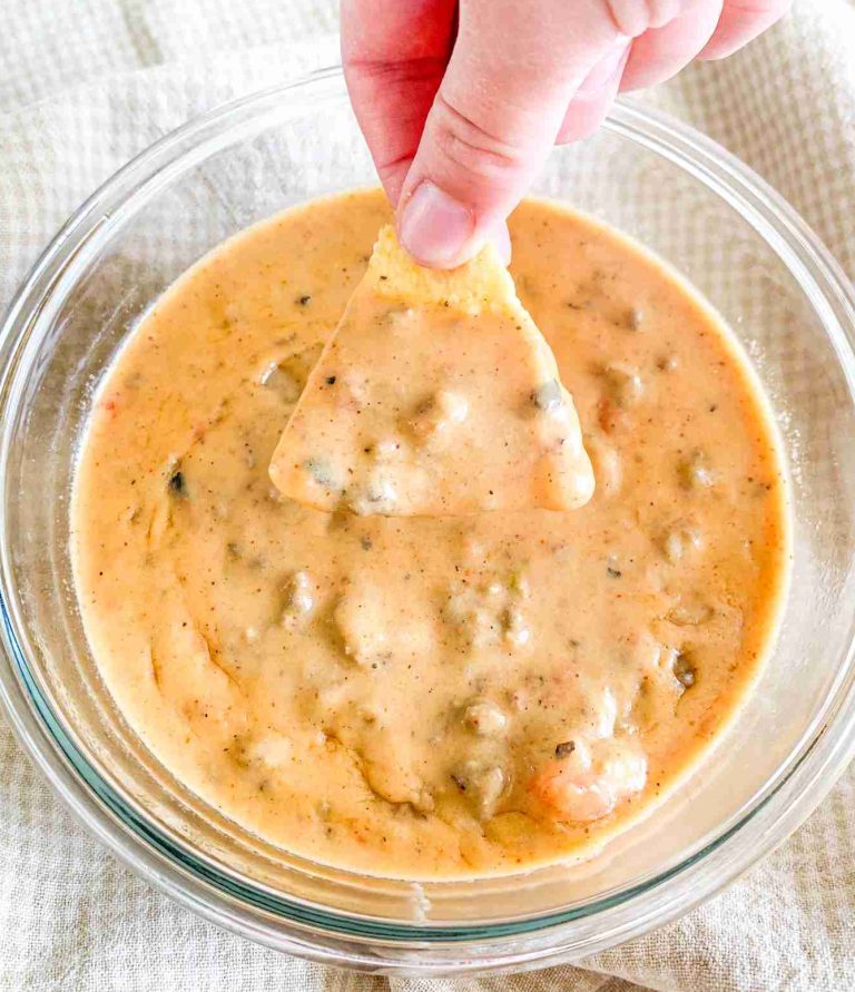 hand dipping a chip into homemade rotel dip