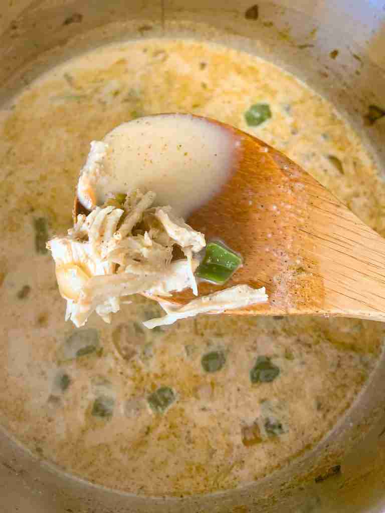 adding shredded chicken into the pot