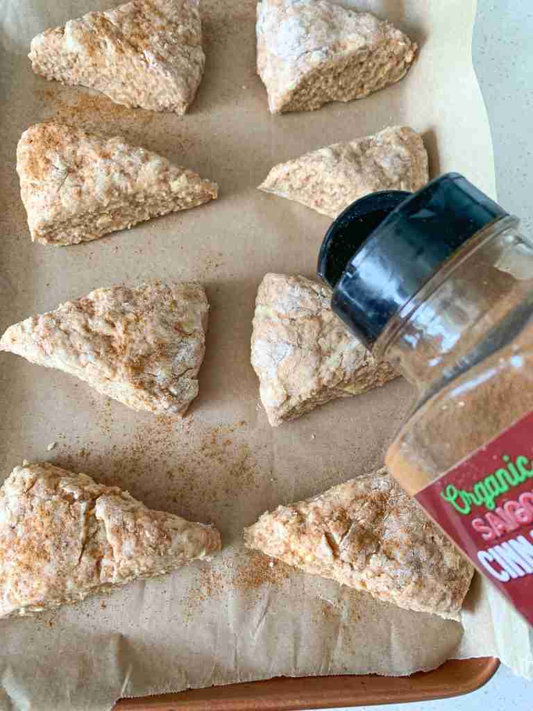 sprinkling cinnamon on top of apple butter scones