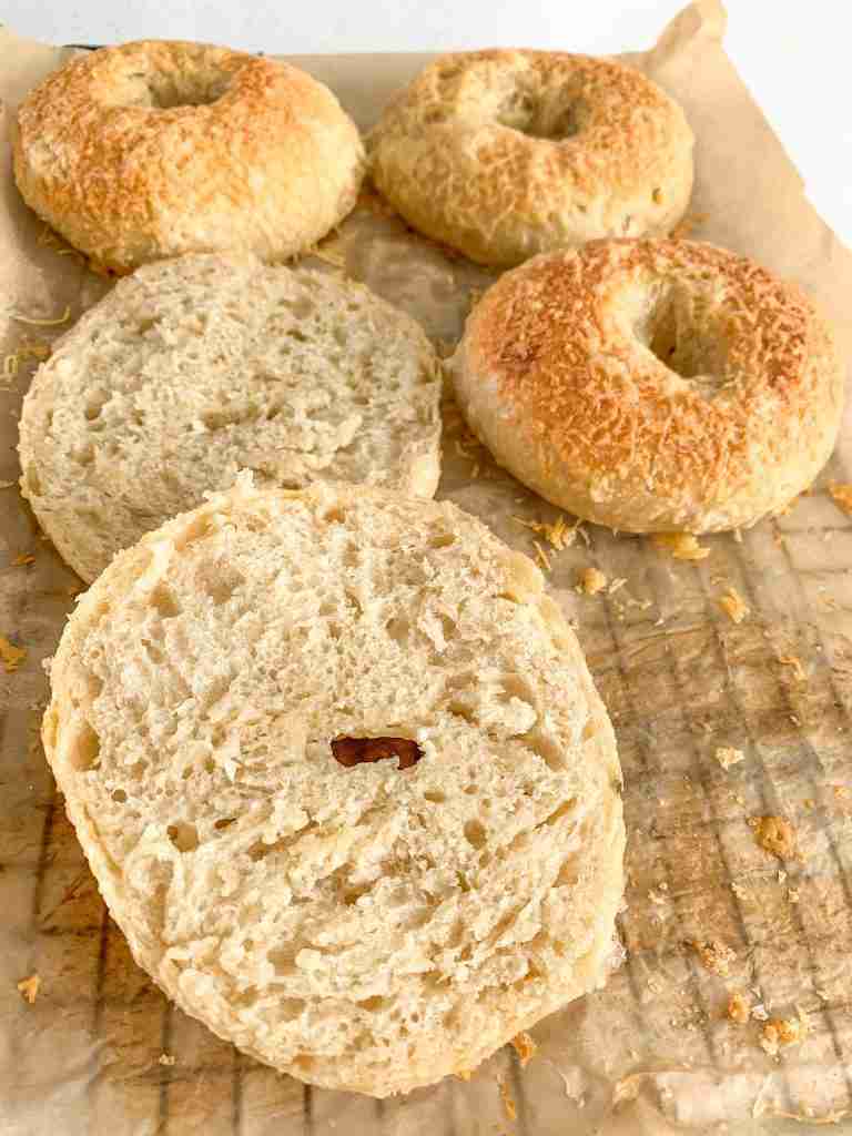 freshly baked sourdough asiago cheese bagels with one cut in half