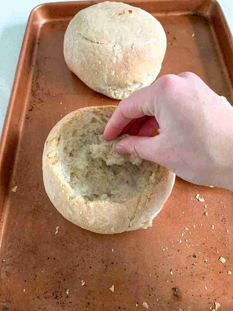 freshly baked sourdough bread bowls getting dug out for soup