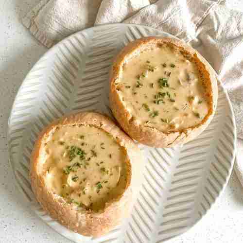 freshly baked sourdough bread bowls with soup in them