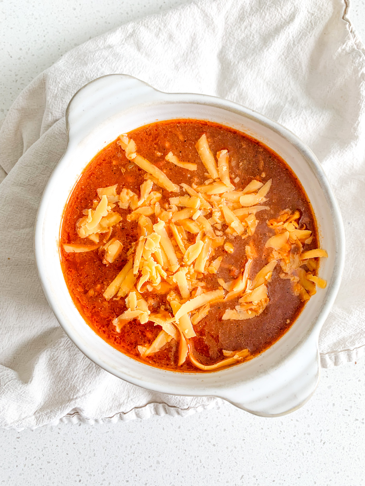 freshly made bowl of game day chili topped with cheese