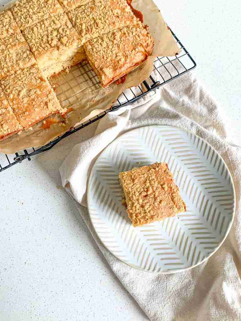 slice of freshly baked sourdough coffee cake on a plate beside the cut cake