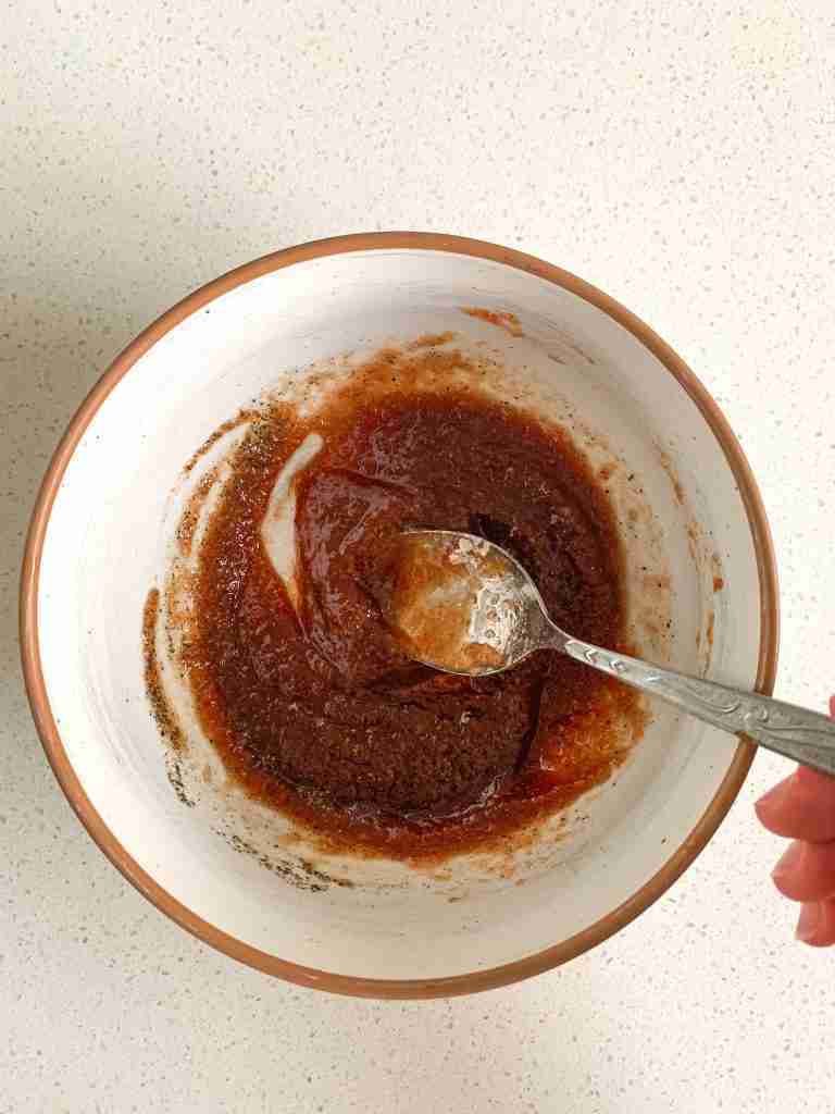 mixing spices and apple butter in a bowl to put on chicken
