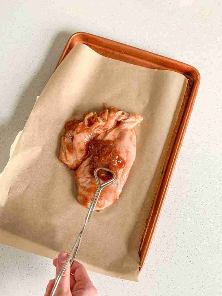 extra apple butter getting spread on chicken breast