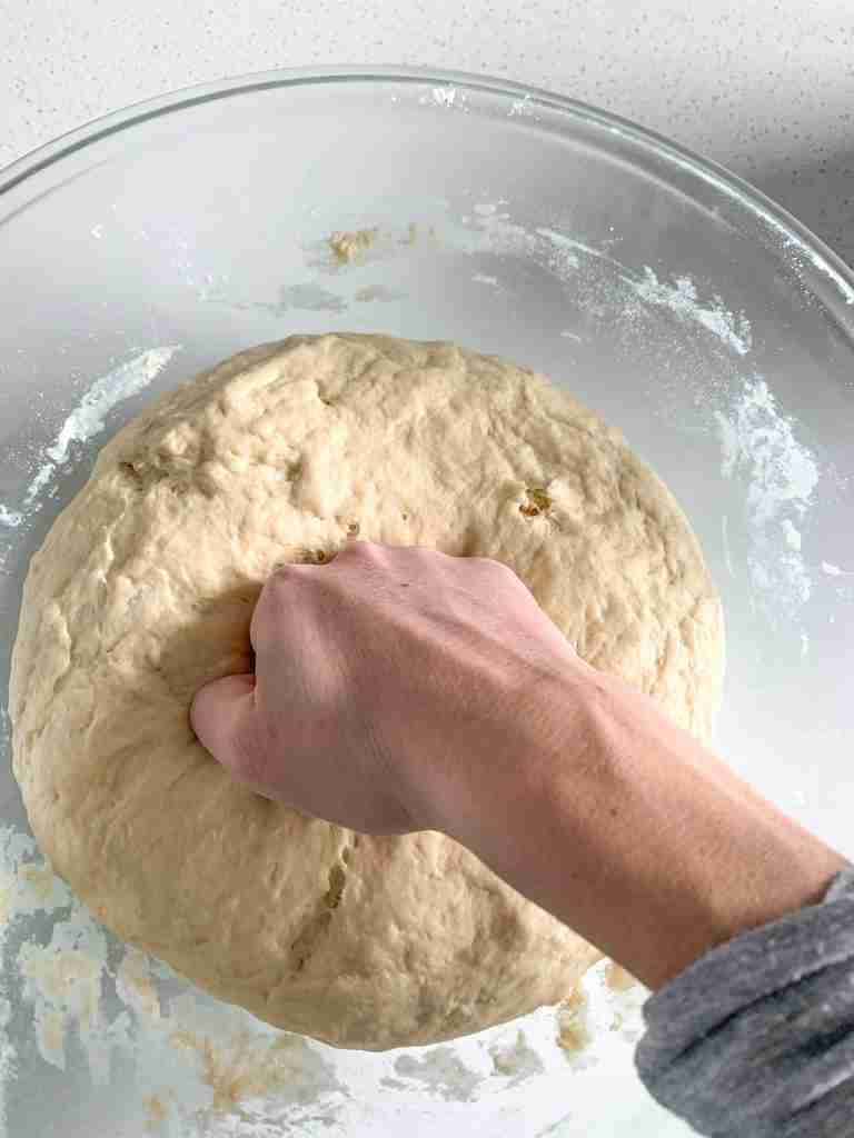 punching fermented dough down for sourdough parker house rolls