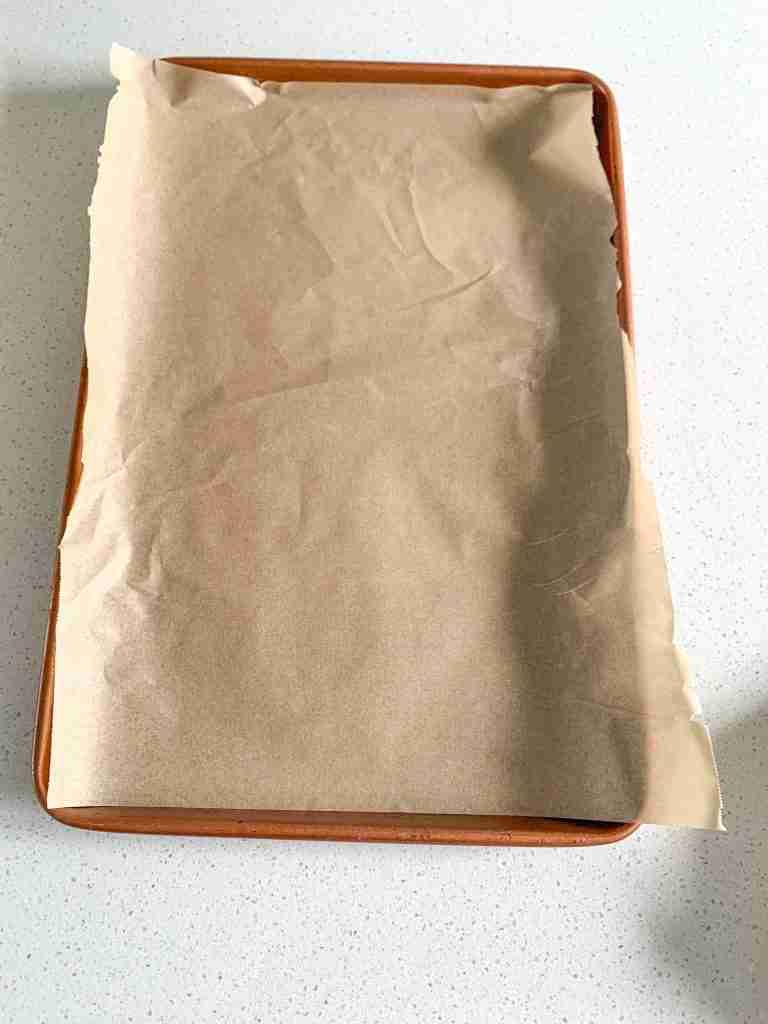 lining a baking sheet with parchment for parker house rolls