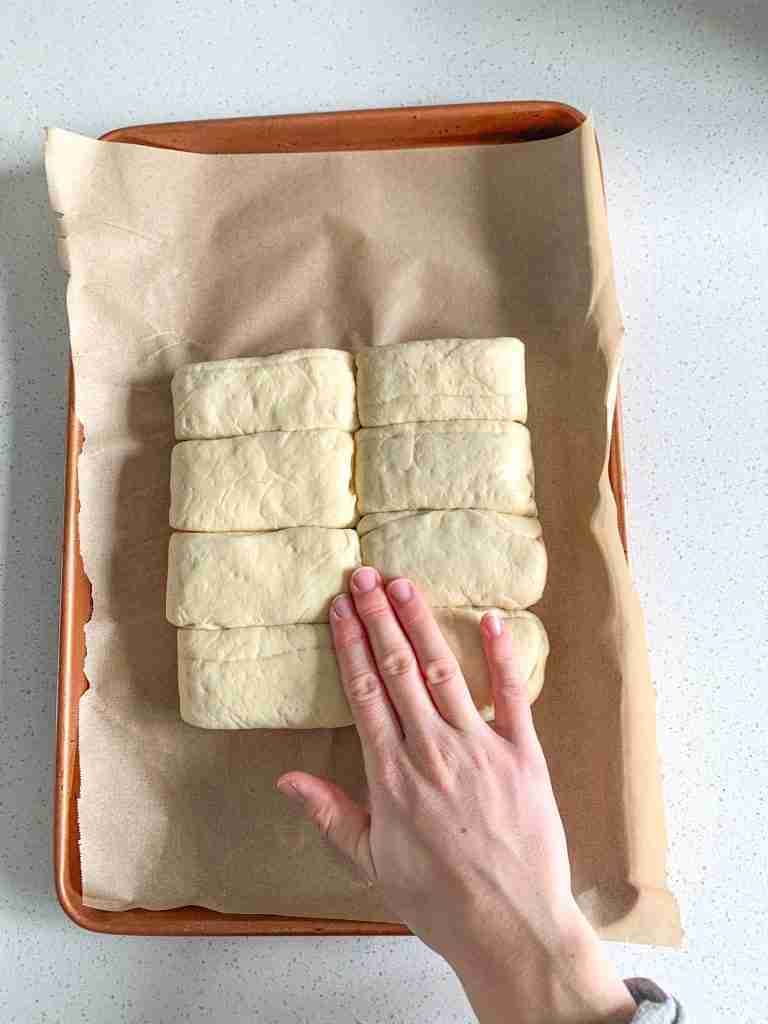 smashing down sourdough parker house roll dough