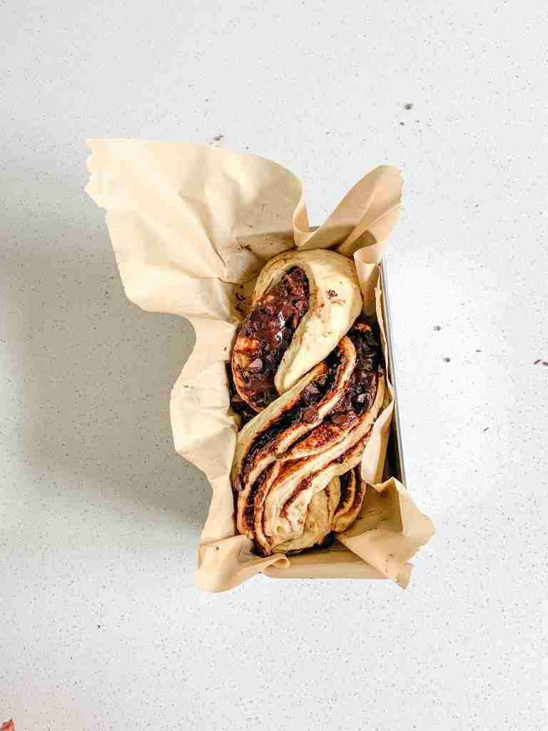 shaped sourdough chocolate babka in a pan ready for baking
