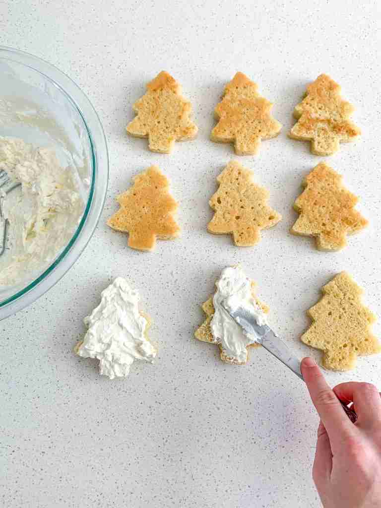 adding the whipped cream frosting layer to the sourdough little debbie christmas tree cakes