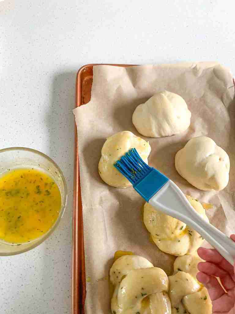 brushing sourdough garlic knot dough with garlic butter