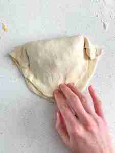shaping calzone dough after filling