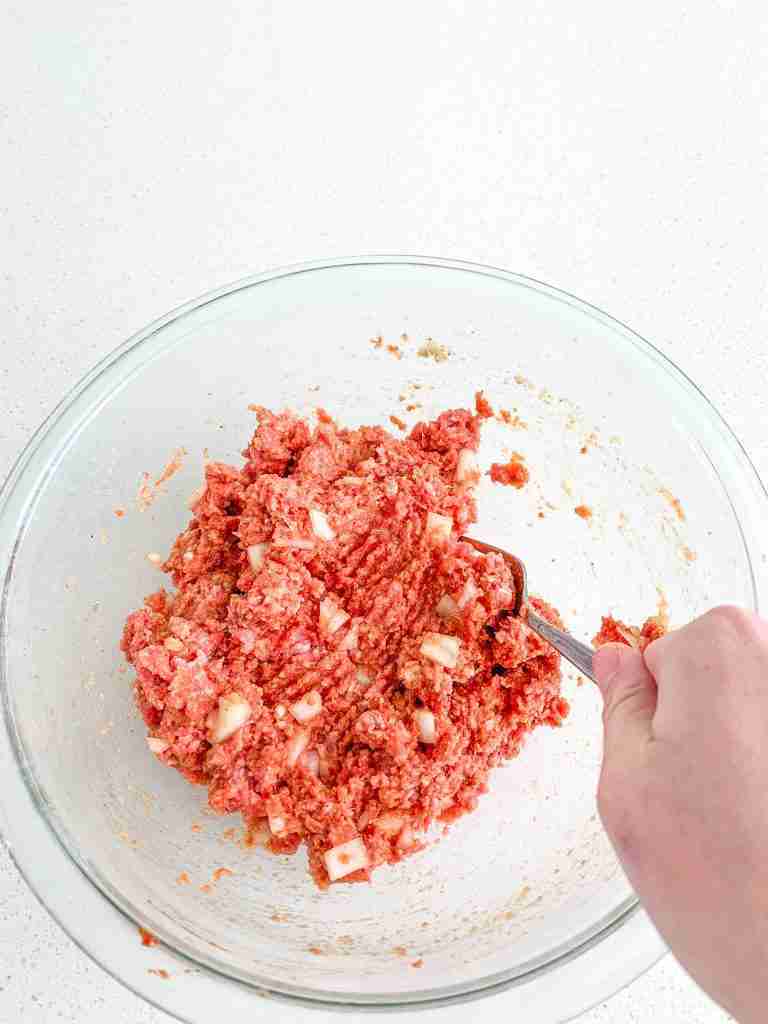 combining ingredients in a bowl for meatloaf burgers