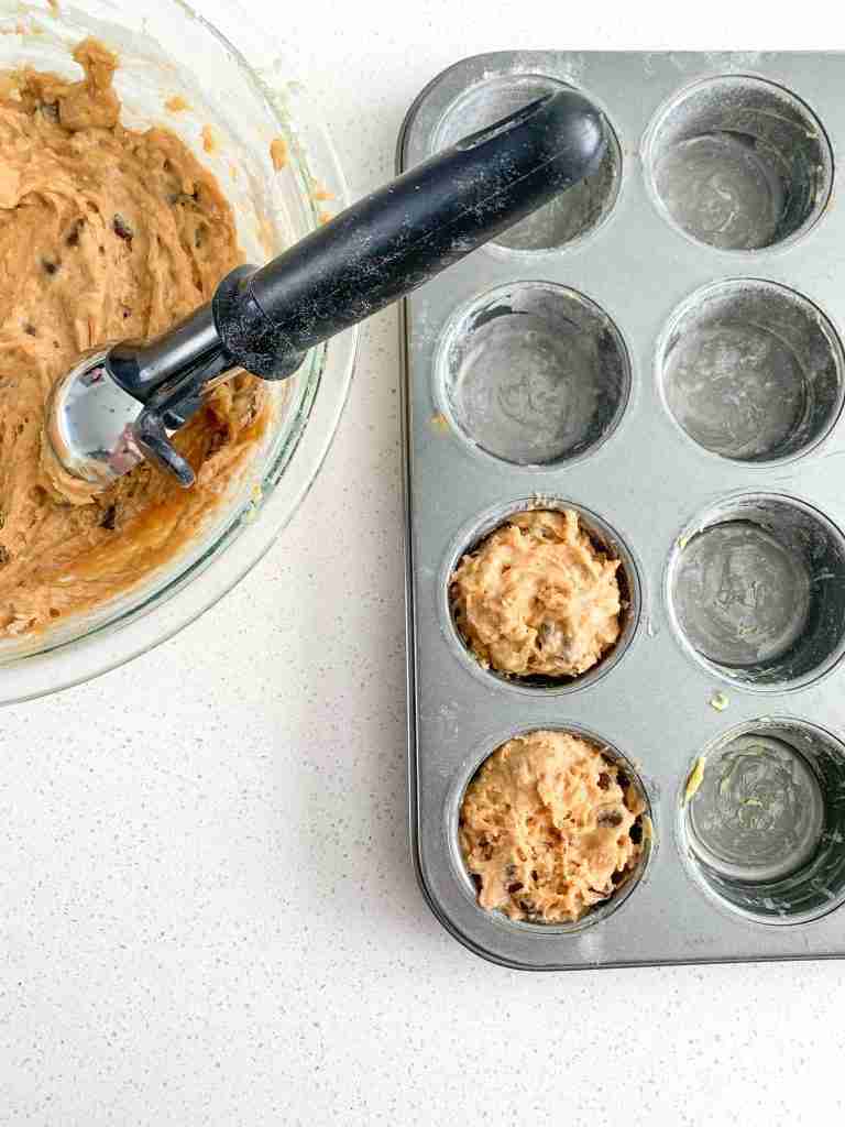 sourdough peanut butter chocolate chip muffins batter getting place in a tin