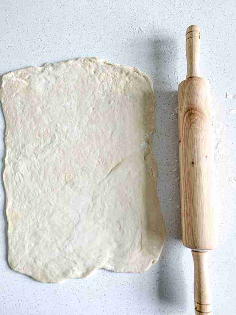 rolled out pizza dough for alabama white bbq chicken bacon pizza