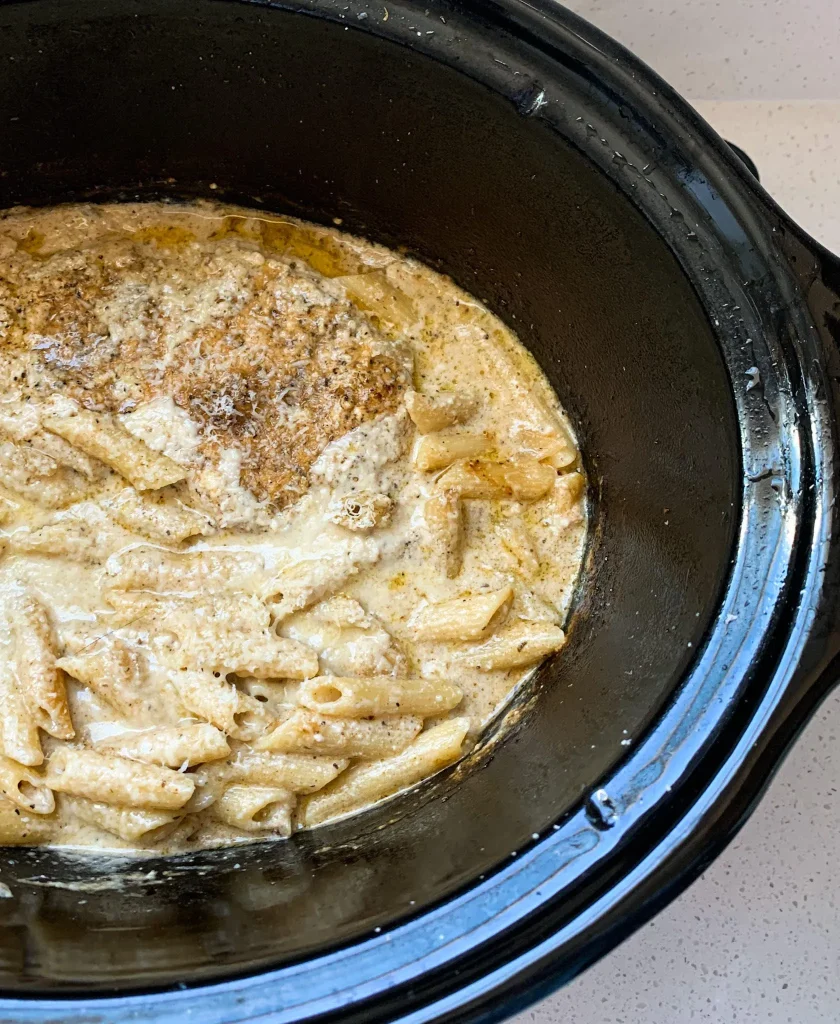 freshly cooked chicken alfredo pasta in a slow cooker