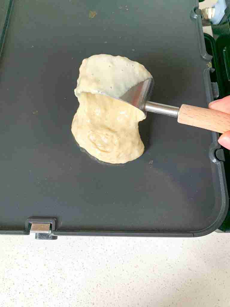 adding sourdough buttermilk pancake batter to a griddle