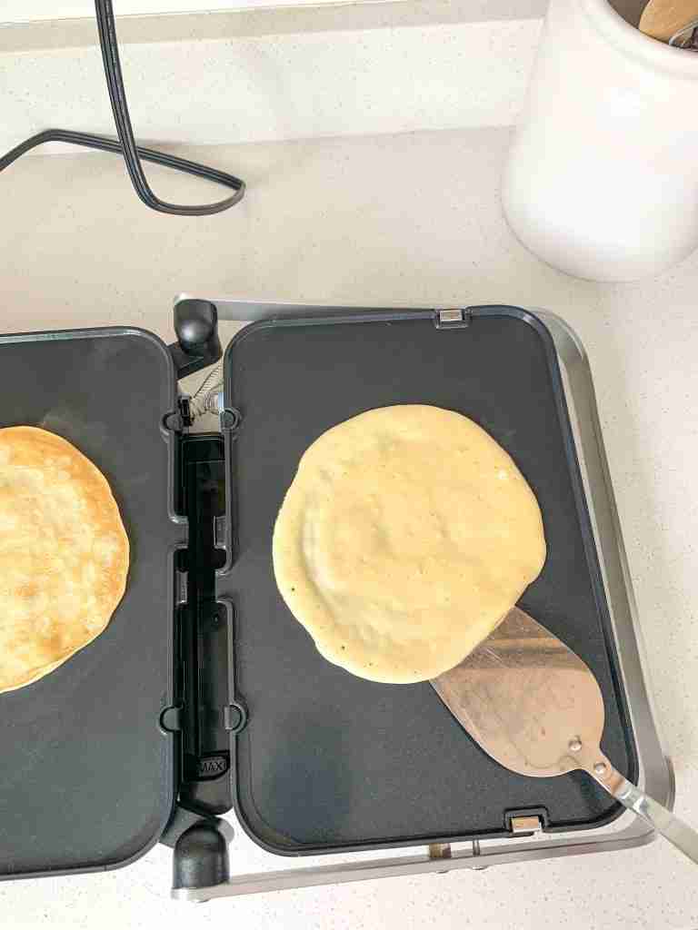 flipping crepes that are cooking on a griddle