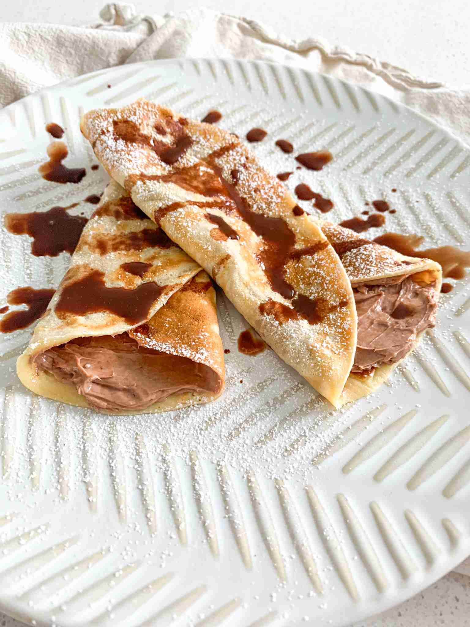 freshly made and filled sourdough crepes drizzled with chocolate syrup