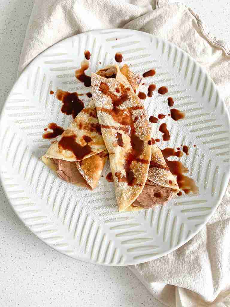 freshly made and filled sourdough crepes drizzled with chocolate syrup