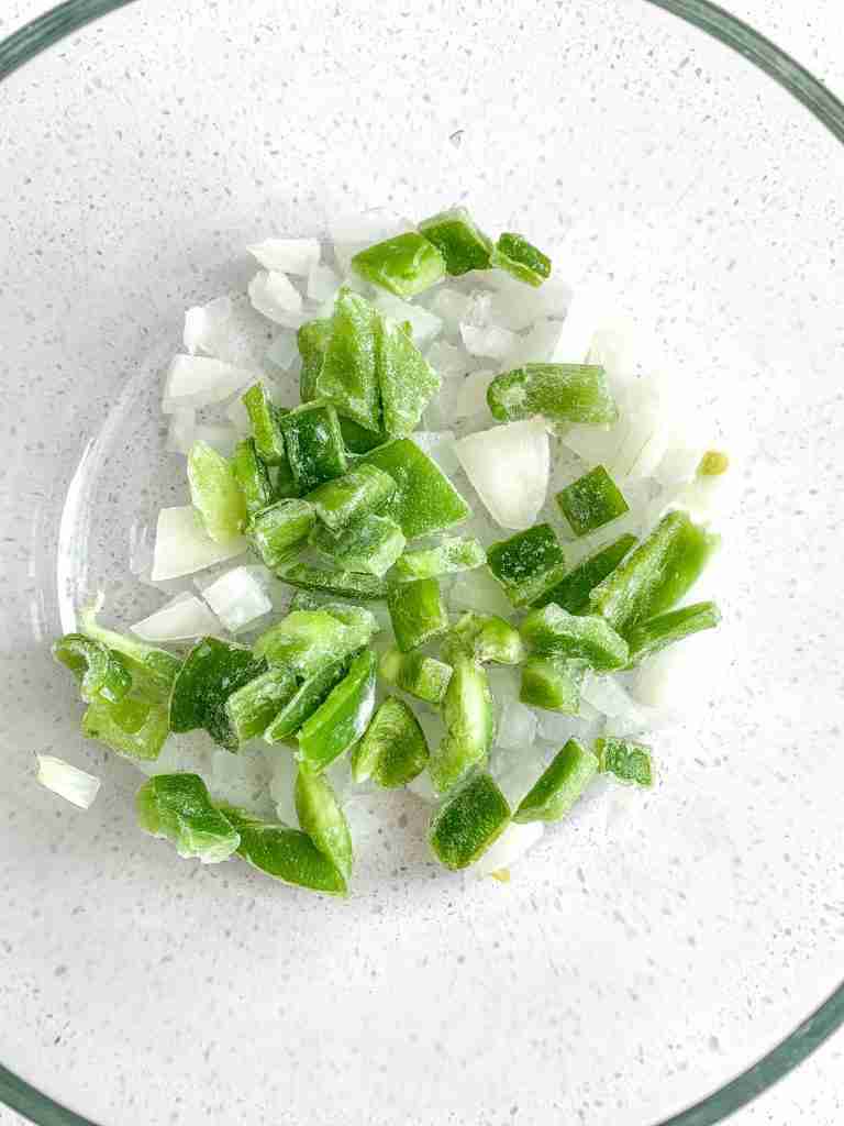 peppers and onions chopped in a bowl for bacon breakfast burritos