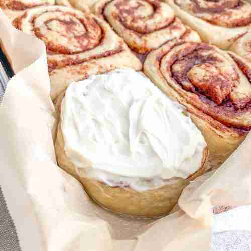 freshly baked and frosted sourdough maple cinnamon rolls