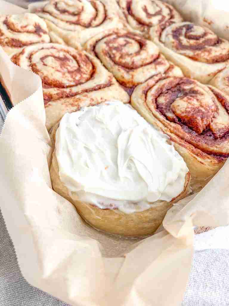 freshly baked and frosted sourdough maple cinnamon rolls