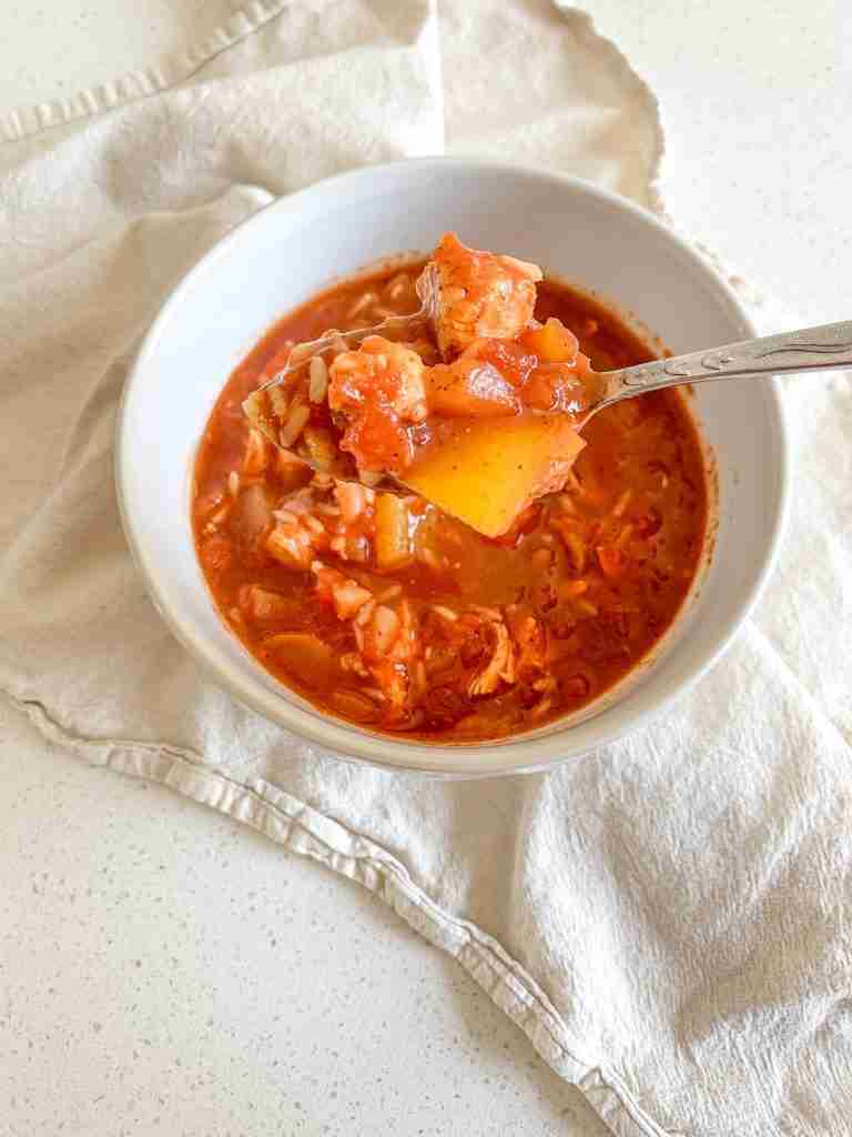 bowl of freshly made mexican chicken and rice soup with a spoonful coming out of it