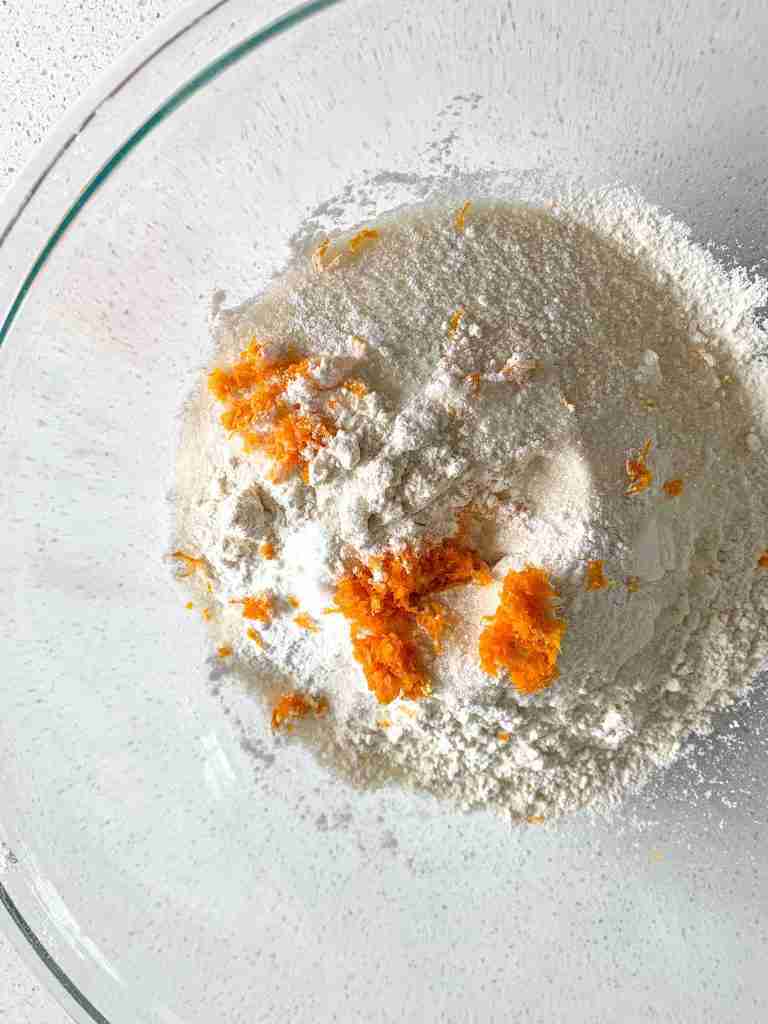 dry ingredients added into a bowl to make sourdough orange scones