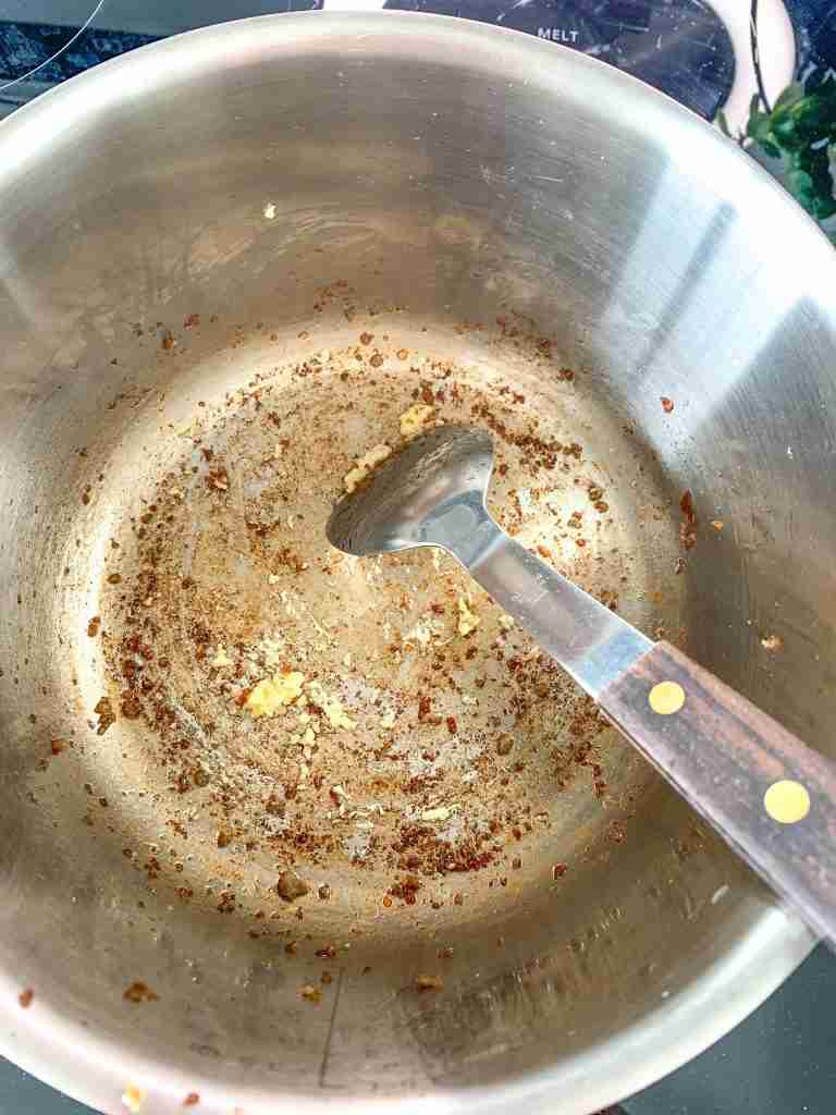 garlic being cooked for Creamy Parmesan Italian Sausage Soup