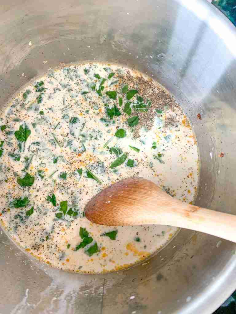 ingredients being stirred and cooked to make for Creamy Parmesan Italian Sausage Soup