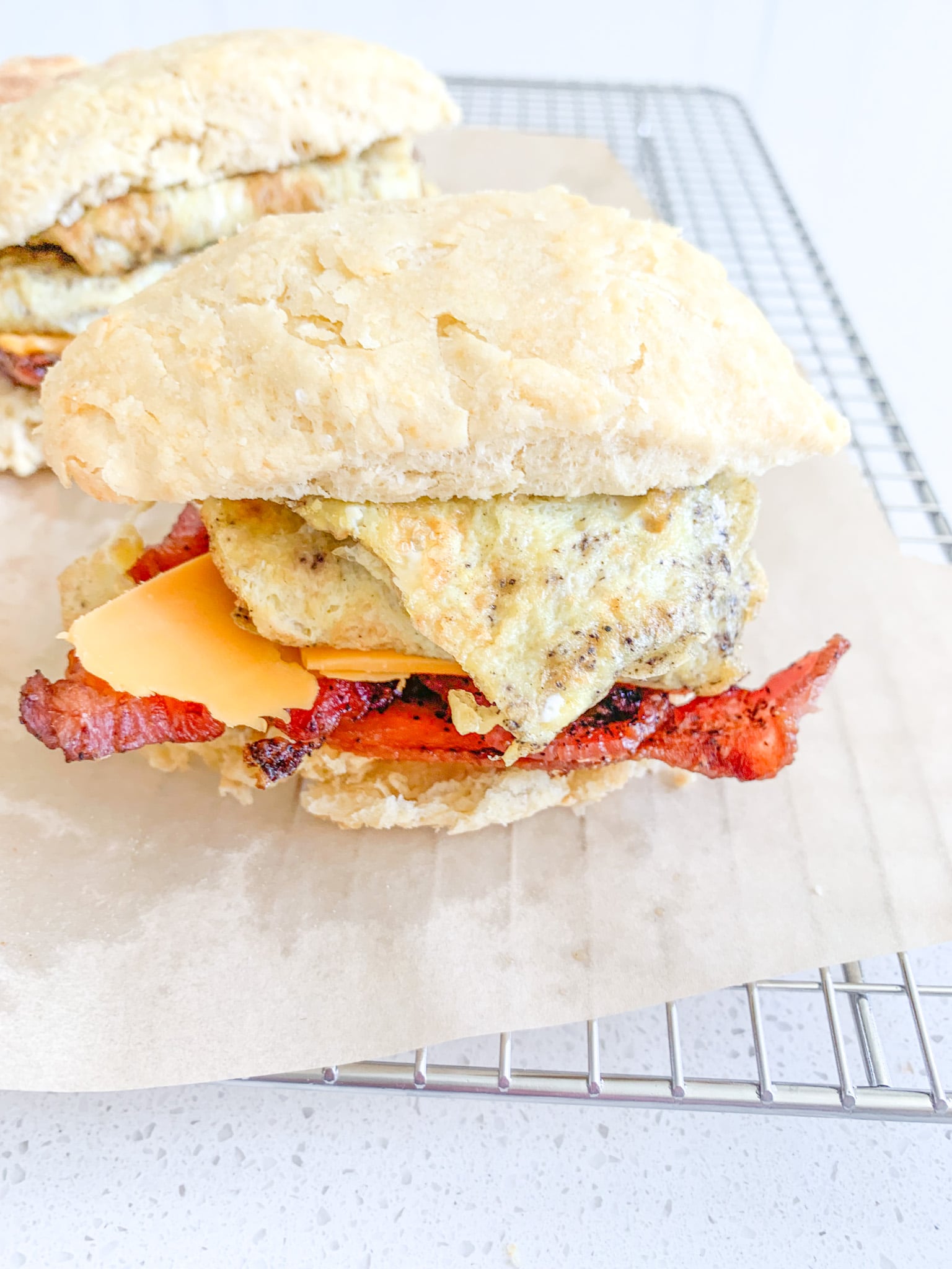 sourdough breakfast sandwich with buttermilk biscuits, eggs, cheese, and bacon