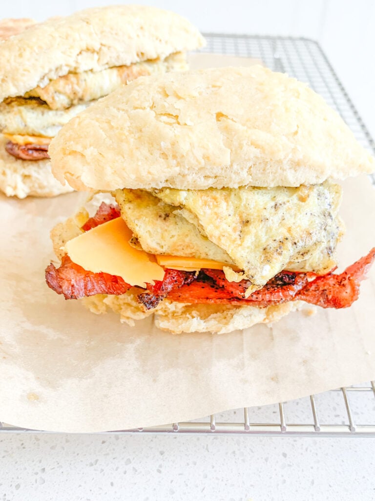 sourdough breakfast sandwich with buttermilk biscuits, eggs, cheese, and bacon