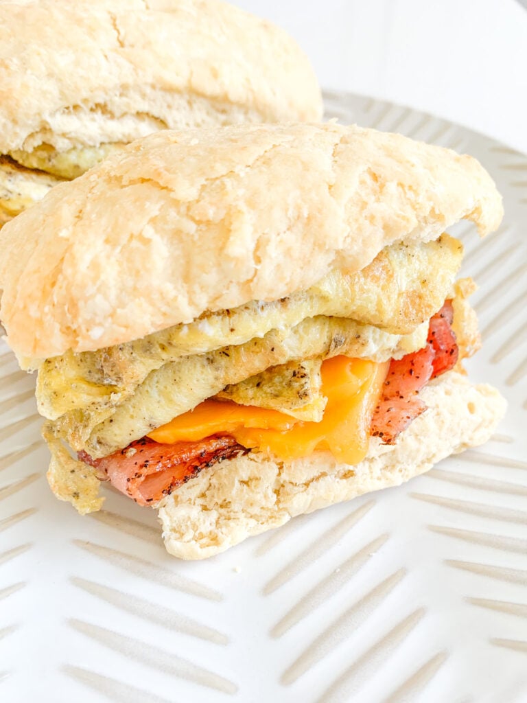 sourdough breakfast sandwich with buttermilk biscuits, eggs, cheese, and bacon