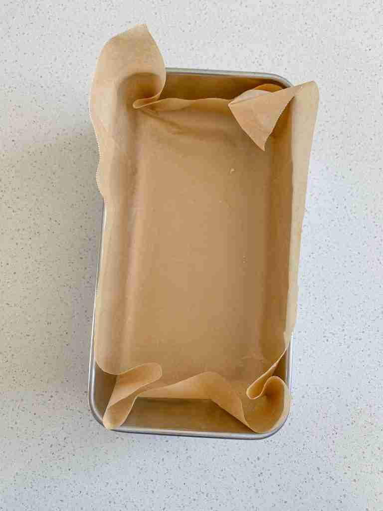 parchment lined loaf pan ready for cheesy sourdough garlic pull apart bread