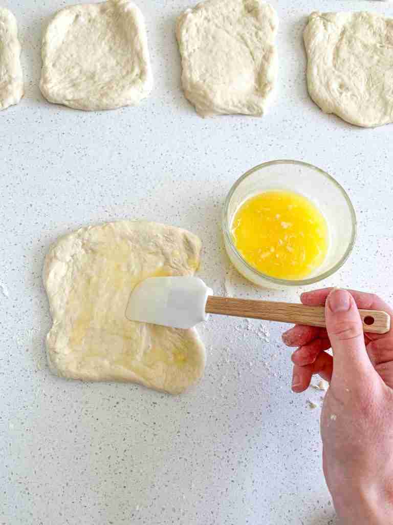 spreading filling on sourdough garlic pull apart bread dough
