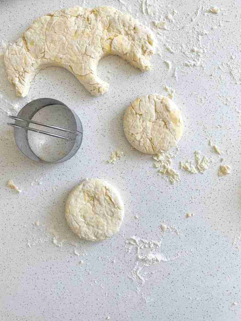 cutting out biscuits for sourdough breakfast sandwiches