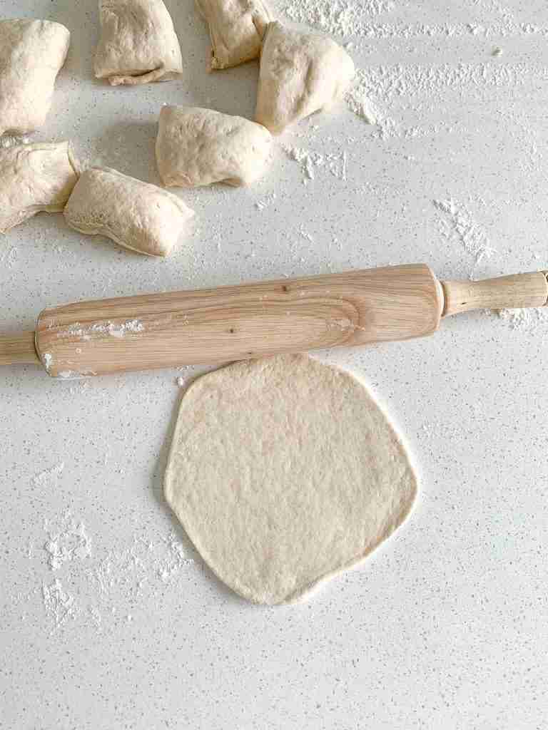 sourdough pita bread dough being rolled out