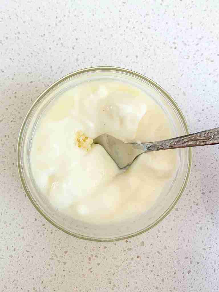 mixing chicken shawarma sheet pan dinner sauce