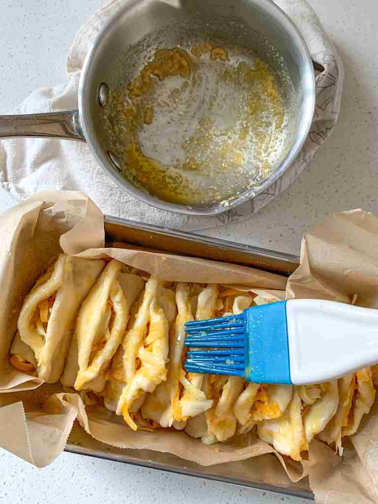 brushing garlic pull apart dough with garlic butter