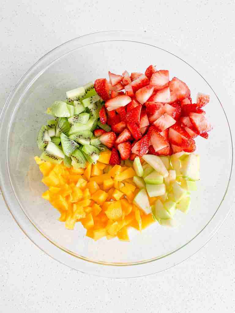freshly made spring fruit salad in a bowl before being mixed
