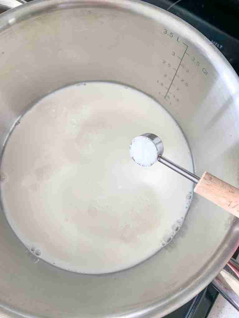 salt being added to milk and water for bacon cheese grits