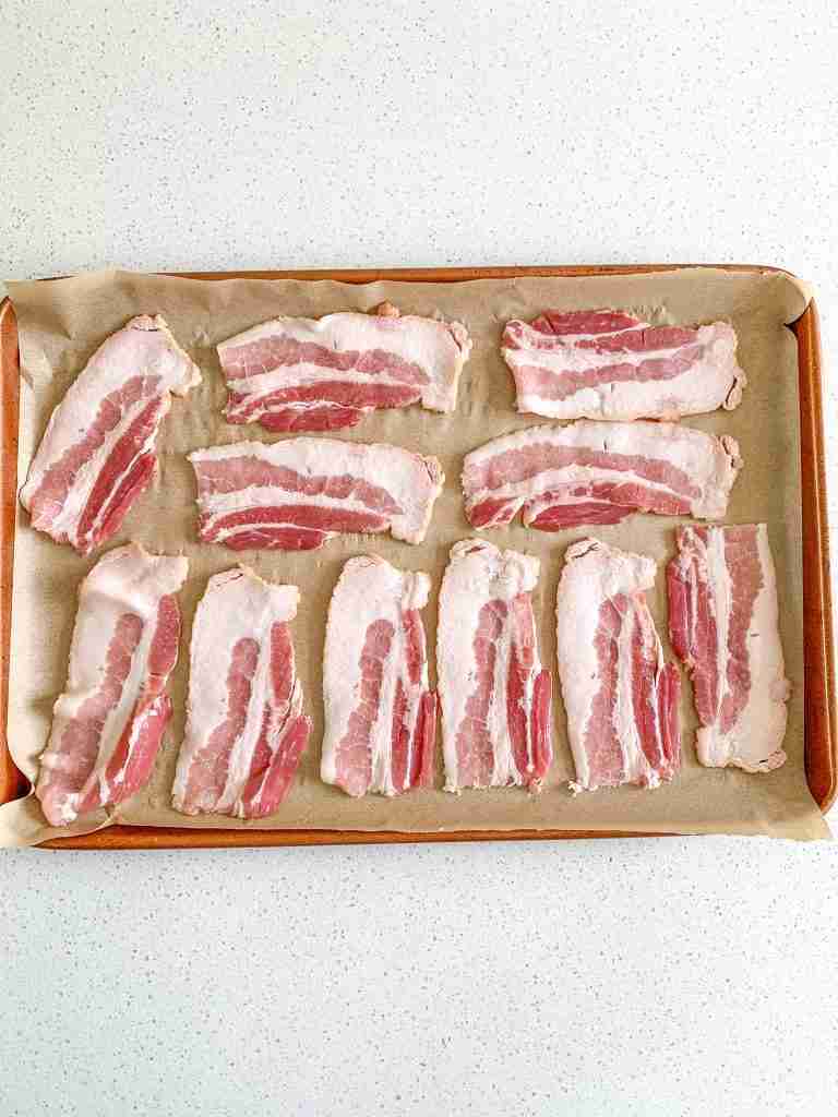 bacon on a sheet pan ready to be baked
