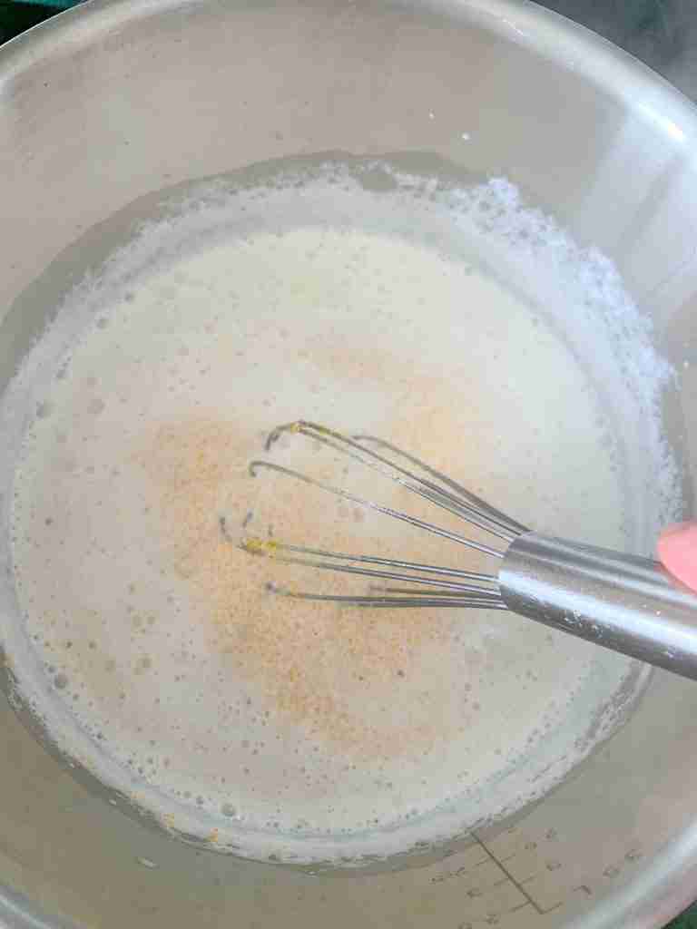 whisking grits into milk mixture for bacon cheese grits