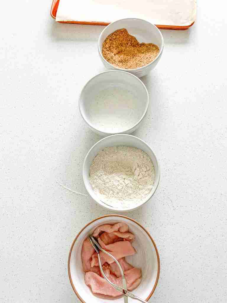 all ingredients lined up and prepped to batter chicken for Buttermilk Fried Chicken Tenders