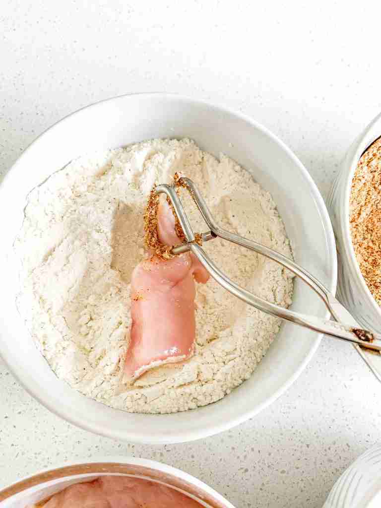 coating chicken in flour for Buttermilk Fried Chicken Tenders