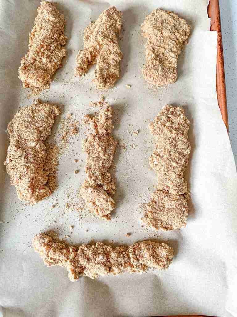 pan of breaded Buttermilk Fried Chicken Tenders ready for oven