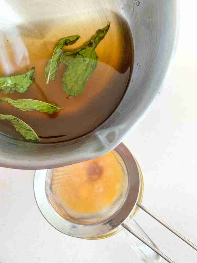 adding mint simple syrup to the pitcher of mint julep punch