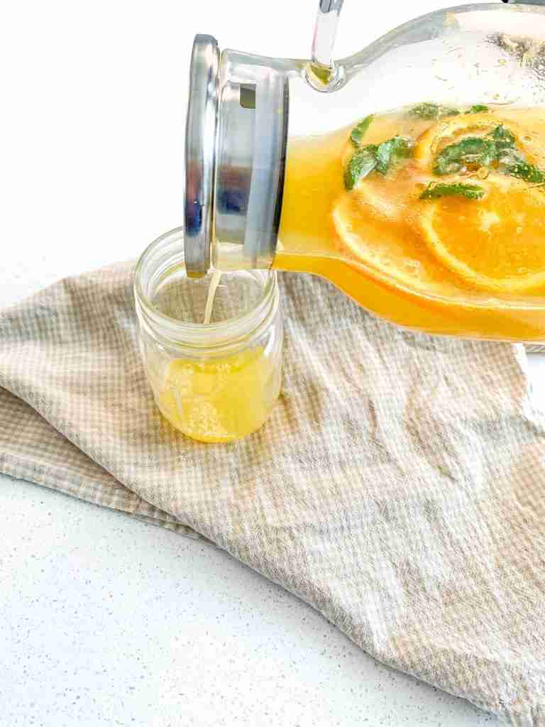 pouring freshly made mint julep punch into a glass